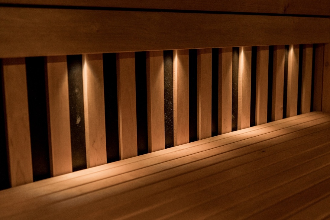 Nahaufnahme der professionellen Installation von Holzlamellen-Akustikpaneelen mit integrierter LED-Beleuchtung.